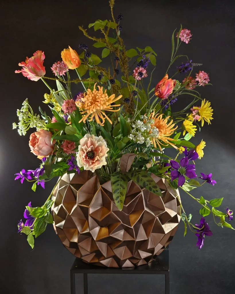 Zijde bloemen in een bloempot op een zwarte bijzettafel